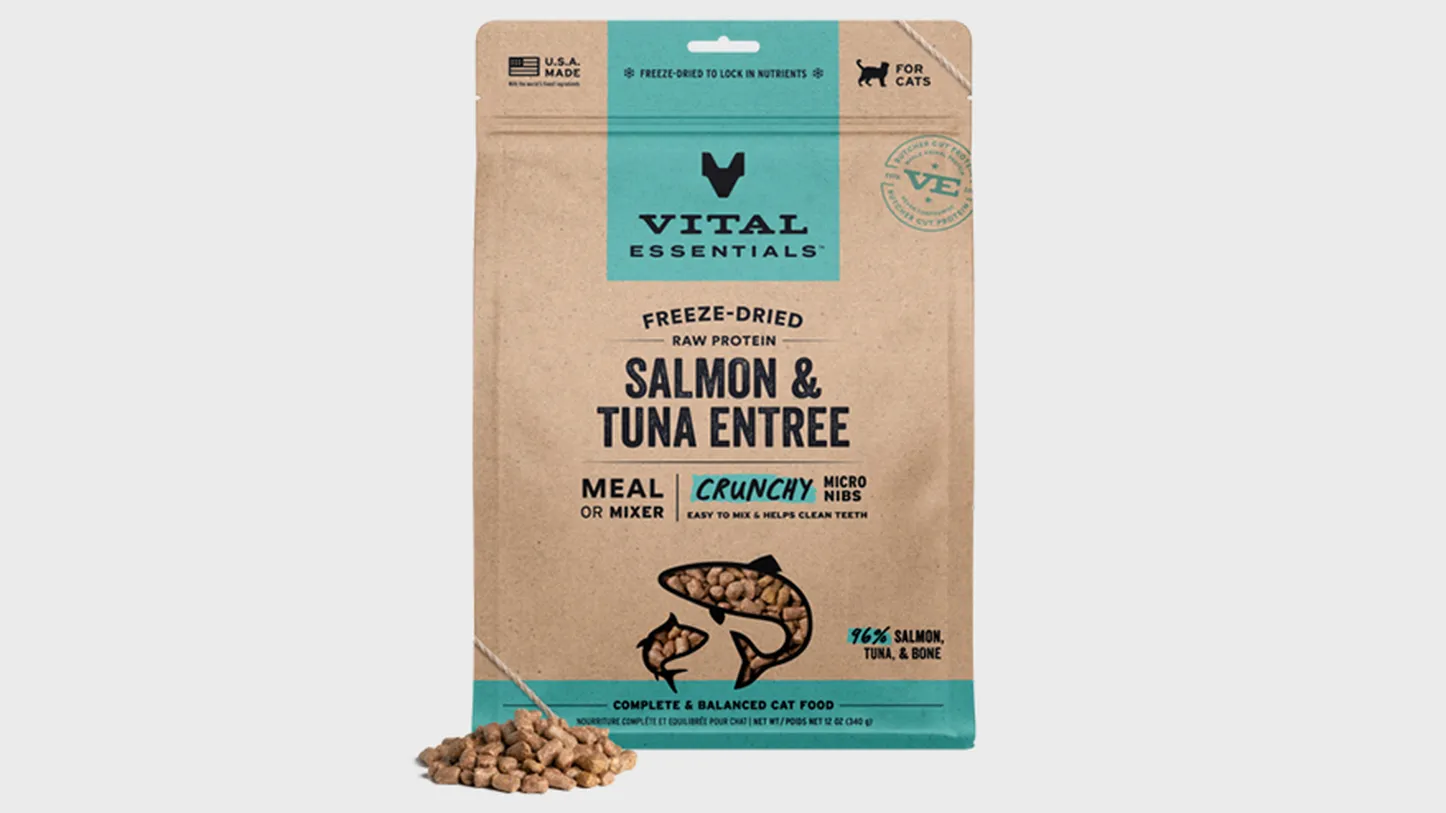 A bag of Vital Essentials freeze-dried salmon and tuna entree cat food, with some kibble pieces in front.